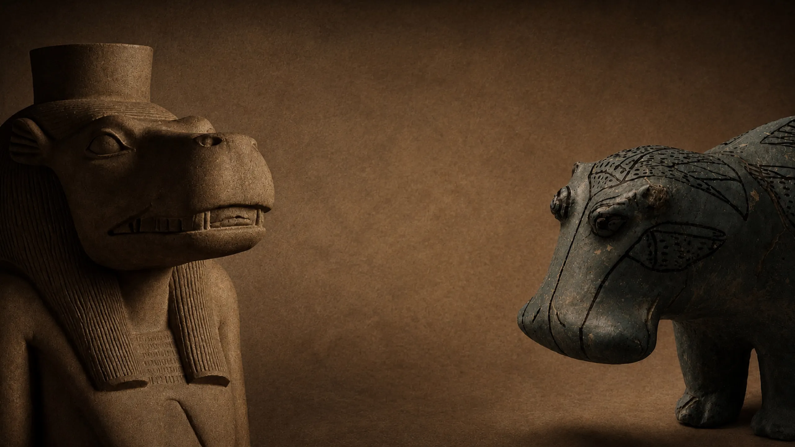 Taweret carved in stone and a faience hippopotamus, facing each other across a brown ground